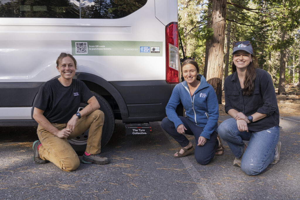 Three scientist in front of a van to show off their filter device. 
