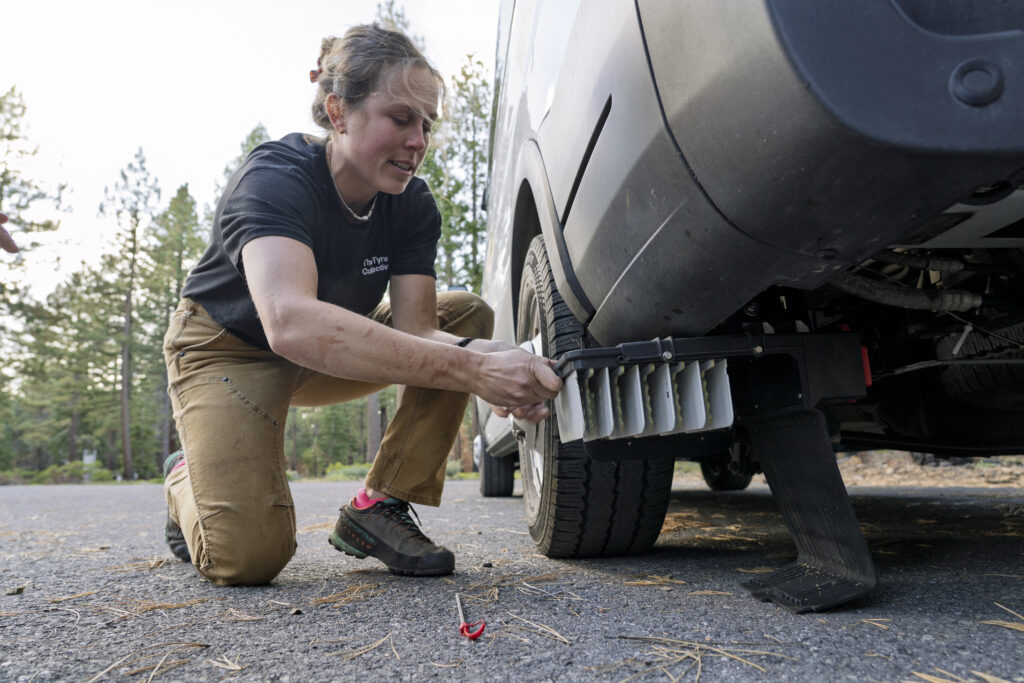 Scientist removing a filter from underneath a van.