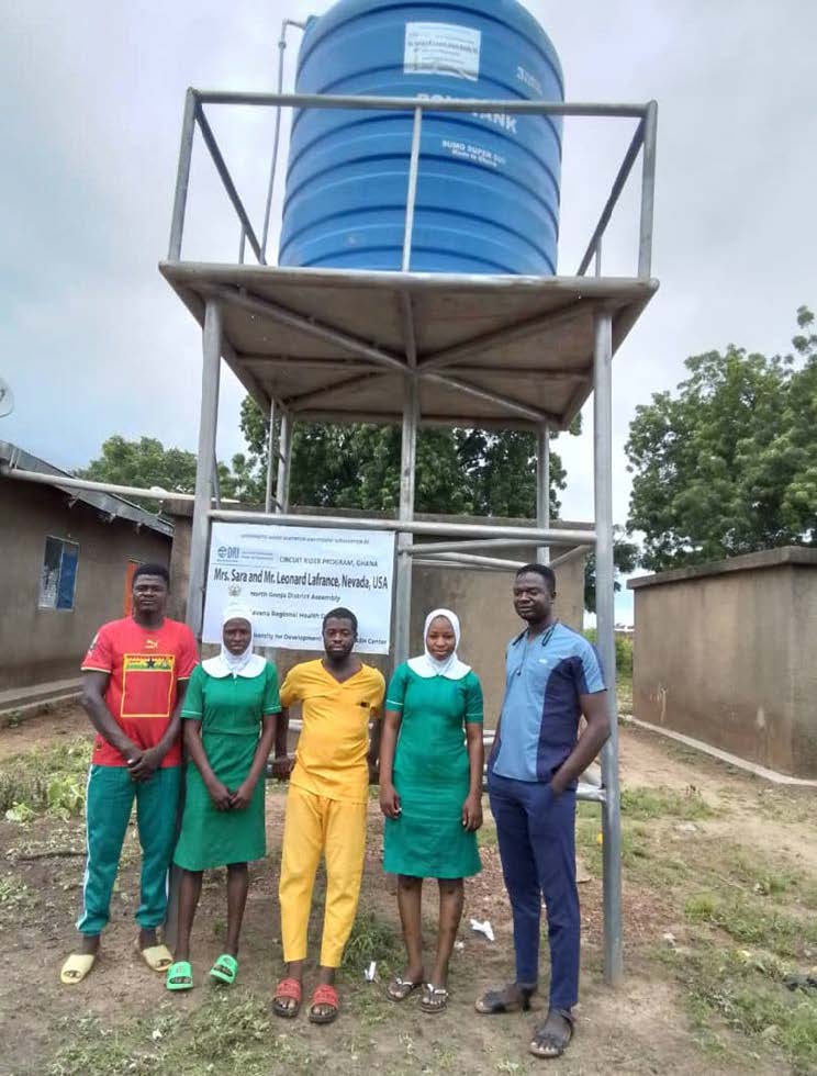 People standing in front of a water tower.