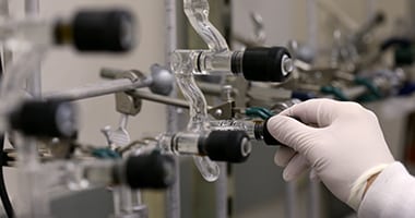 scientist wearing a latex glove adjusts lab equipment