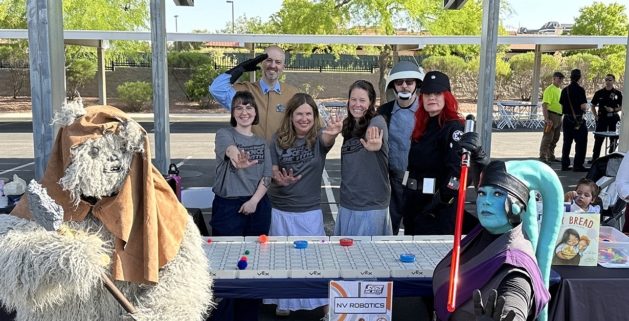 Community Outreach Photo Nevada Robotics MTSBWY Featured Image Nevada Robotics staff behind an outreach booth using the force with star wars characters.