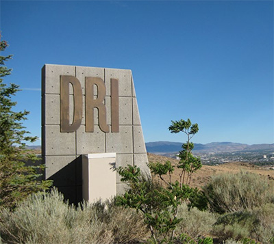 Screenshot DRI sign with desert landscaping and blue sky.