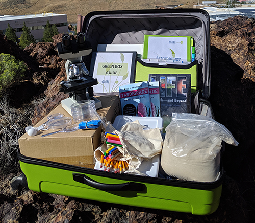 GreenBox Image Green suitcase with supplies and binders and handouts for a STEM lesson.