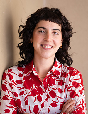 IVANOVICH_300px Headshot of Casey smiling at the camera wearing a red and white collared shirt on a neutral background.