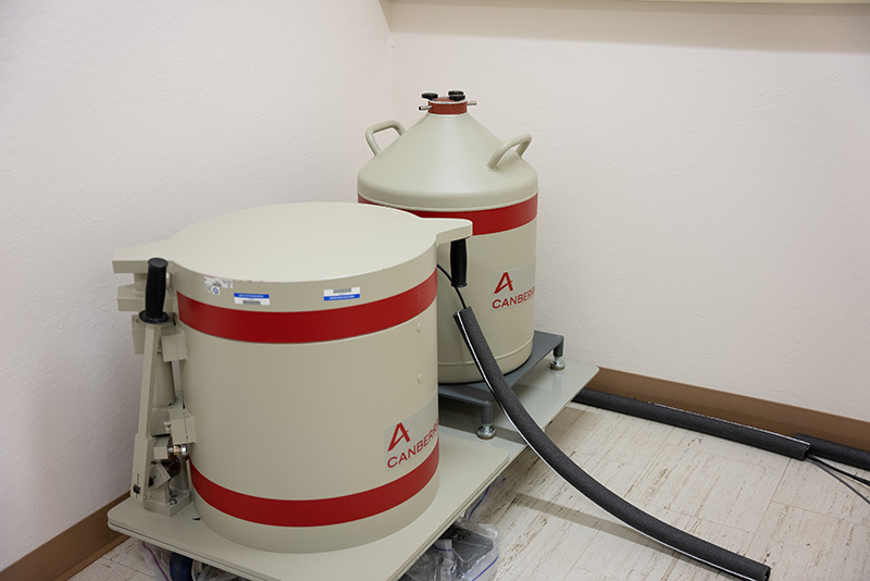 Luminescence-139_Web Two white and red tanks in the corner of a lab.
