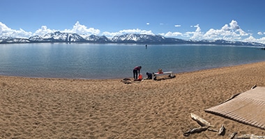Researcher at a Lake Tahoe beach collecting water samples