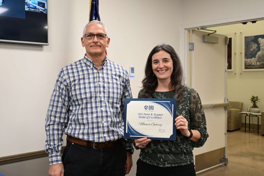 A woman holding a certificate standing next to a man. 