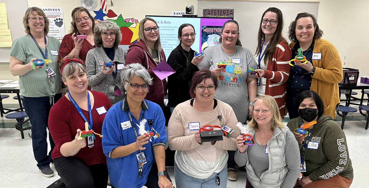 NVRobotics_PD_Event Teachers posing in a group with their robots created during a training event.