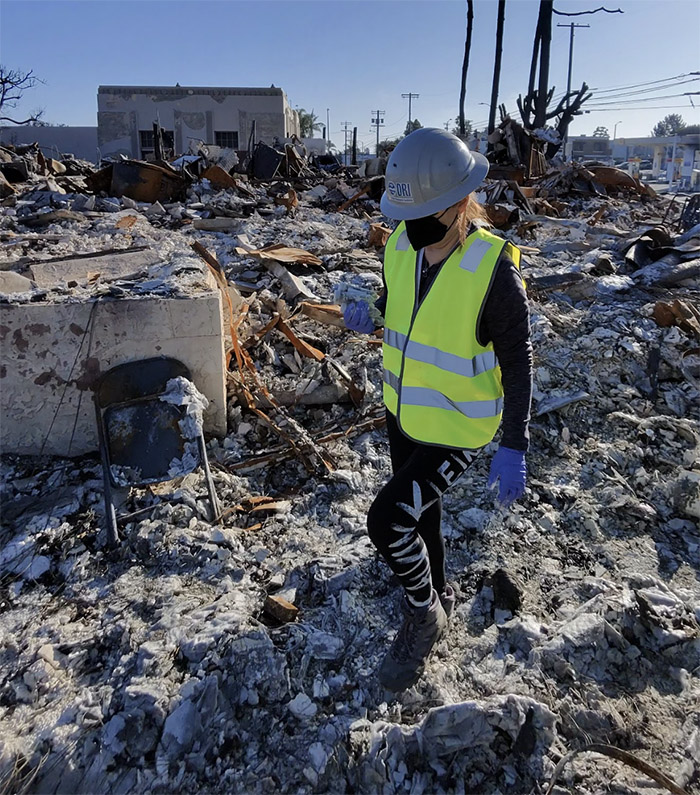 Dr. Vera Samburova walking through wildfire rubble.