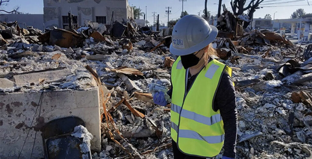 Dr. Vera Samburova walking through wildfire rubble.