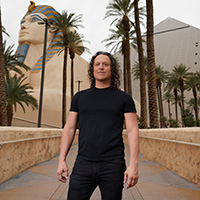 Jarret Keene standing in front of Luxor Las Vegas with palm trees.