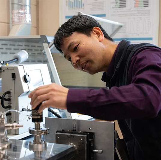 Screenshot Researcher using equipment in a lab.