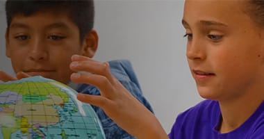 kids looking at a globe