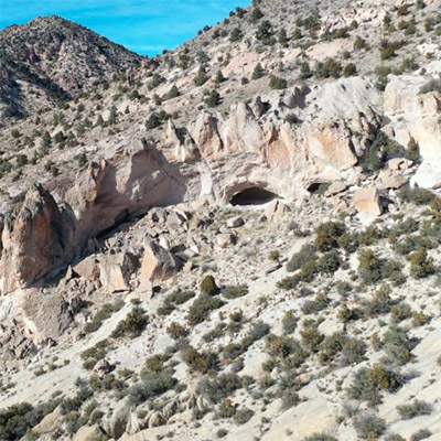 A small cave is visible in the rocky landscape. 