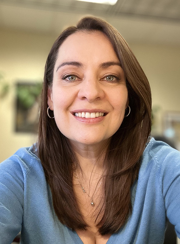 Selfie style photo of Dr. Vera Samburova. Wearing a blue shirt and smiling.