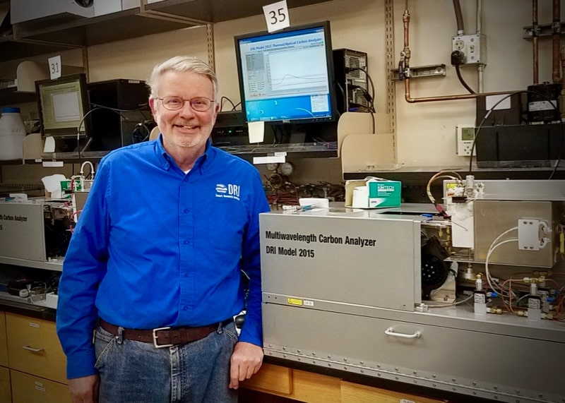 John Watson, Ph.D. stands next to a Multiwavelength Carbon Analyzer