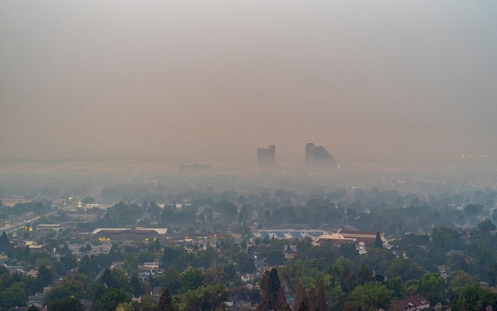 A smoky haze overs the city of Sparks, NV obscuring the buildings and mountains in the distance.