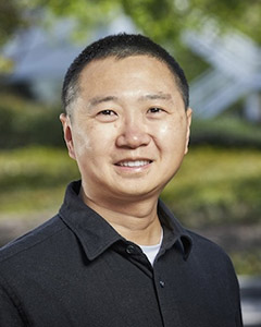 Headshot of Ziming Ke smiling and wearing a black polo shirt. 