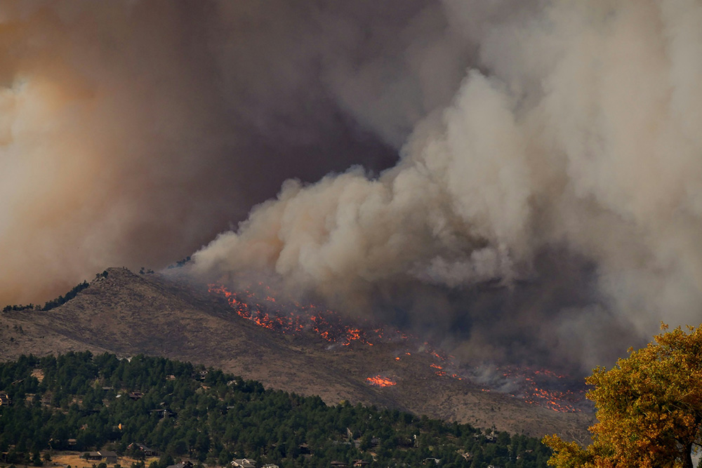 Fires dot a mountainside with dense smoke billowing into the sky.